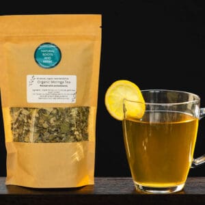 A cup of tea and bag of tea on a table.