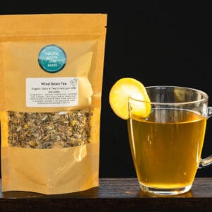A cup of tea and bag of tea on a table.