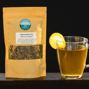 A cup of tea and bag of tea on a table.