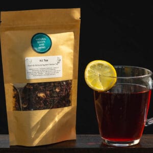A cup of tea and bag of tea on a table.